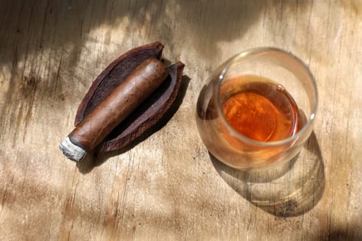 elevated view of close up cigar and drink on wooden table