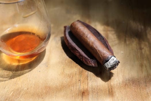 Close up cigar and drink on wooden table