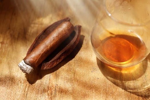 Close up cigar and drink on wooden table