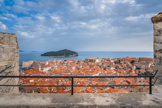 Rooftops of old houses in Dubrovnik, viewed from the Old Town fortified walls with Lokrum Island in the background