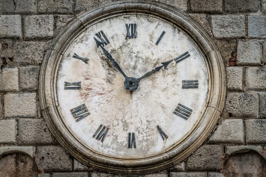 The close up of the Clock on the facade of the Tower on the Square of Arms in the Old Town of Kotor in Montenegro