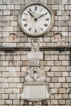 The close up of the Clock on the facade of the Tower on the Square of Arms in the Old Town of Kotor in Montenegro