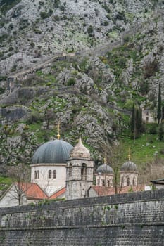 St. Nicholas Church Dome and the massive walls of the fortification Bastion Riva by the river Shkurda in Kotor Old Town, Montenegro