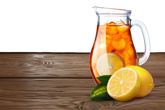 Jug or pitcher of iced tea with lemons on foreground standing on wooden table. Clipping paths for both background and pitcher, infinite depth of field