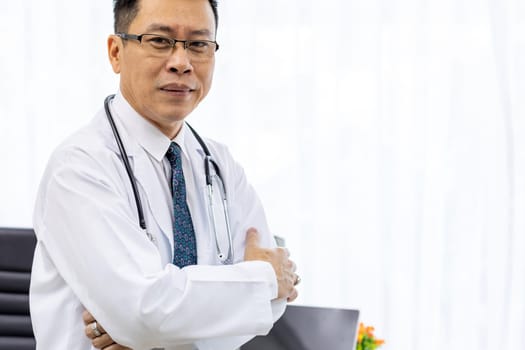 Portrait of senior Doctor in examination room medical office.