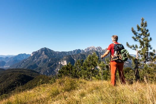 Man hiker is  admiring the range mountains landscape.
