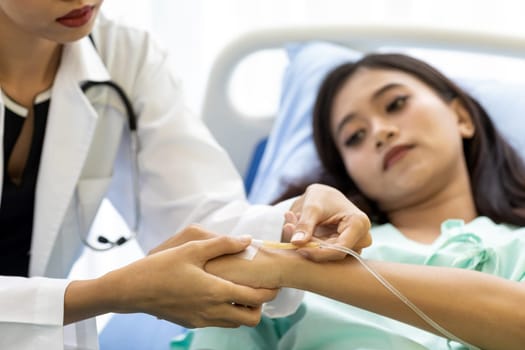 Female doctor preparing a saline tube for patient in the hospital.