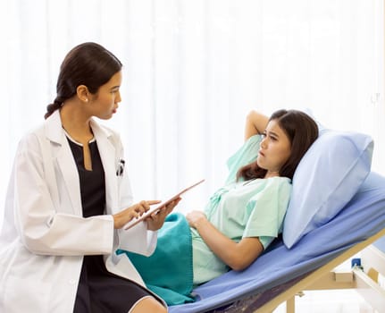 Asian Doctor make routine health check with patient in hospital ward