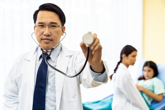 Portrait of Young adult Doctor with nurse and Patient in background.