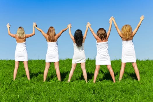 Woman group in towel on the summer meadow