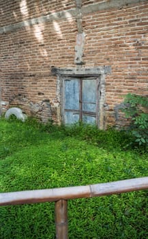 Zinc gate with old bricks wall and grass field, stock photo