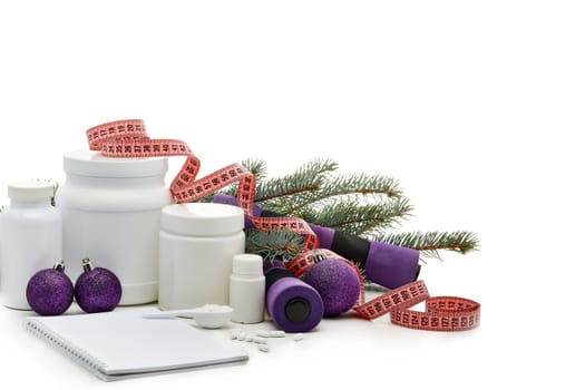 Sports nutrition (supplements), dumbbells, fir tree branches and christmas ormament on a white background. Horizontal view. New Year and Christmas. Fitness. Healthy lifestyle.