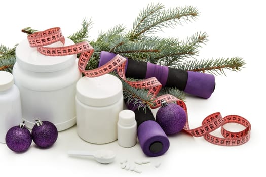 Sports nutrition (supplements), dumbbells, fir tree branches and christmas ormament on a white background. Horizontal view. New Year and Christmas. Fitness. Healthy lifestyle.