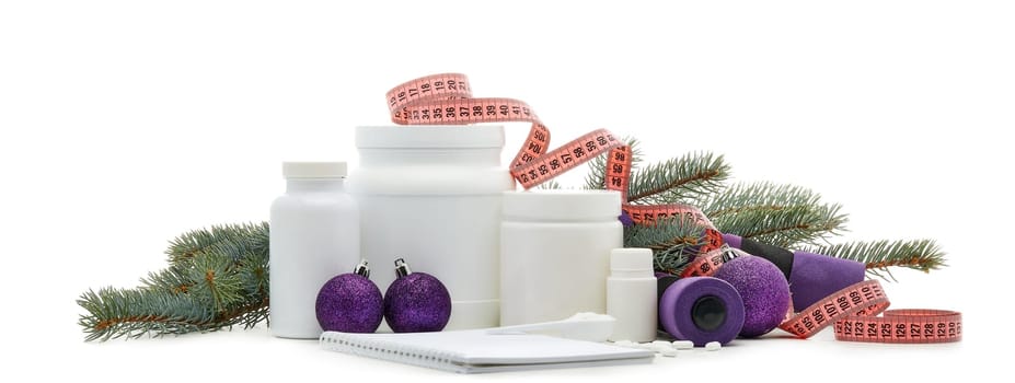 Sports nutrition (supplements), dumbbells, fir tree branches and christmas ormament on a white background. Horizontal view. New Year and Christmas. Fitness. Healthy lifestyle.
