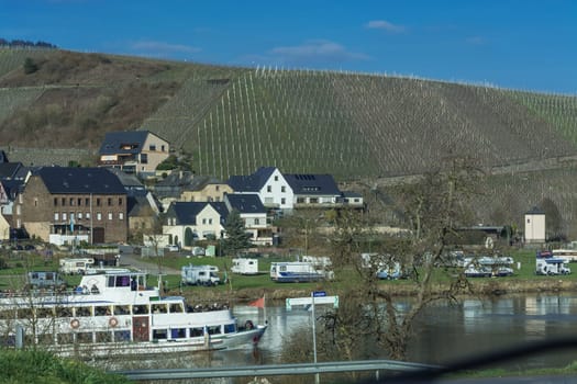 TRABEN-TRARBACH, GERMANY - MARCH 26, 2016:.Passenger ship MS Berlin on the Moselle near the town of Traben-Trarbach in Germany. In the background mobile home on a campsite