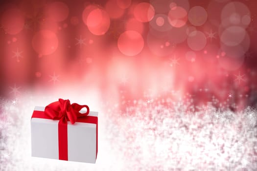 Christmas or Happy New Year decoration background. Christmas gift box on white snow and snowflakes over abstract festive red winter background. Template for your product display montage. Card concept.