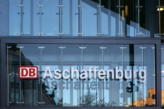 Aschaffenburg, Germany - November 17, 2018: The modern glass facade as a design element with logo of the Deutsche Bahn of the Aschaffenburg central station on November 17, 2018 in Aschaffenburg..