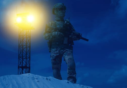 US Military security service serviceman in camo uniform, helmet and mask, armed with assault rifle standing in backlight beam of war watchtower search light. Military base or prison night watch guard
