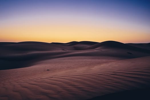 Sand dunes against sky before sunrise. Desert Wahiba Sands in Oman.