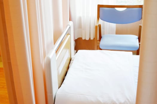 Medical privacy curtain and empty bed in a hospital room