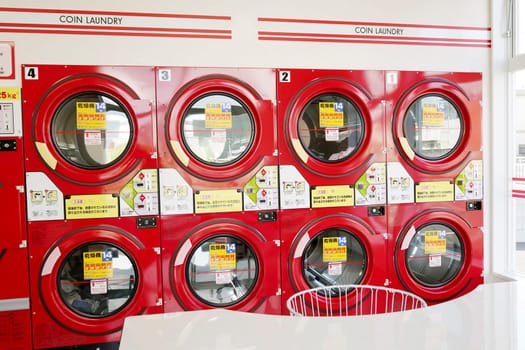 KAGAWA, JAPAN - OCTOBER 29, 2018: Row of industrial washing machines in a public laundromat