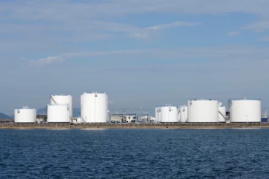 Industrial fuel storage tanks against the blue sky