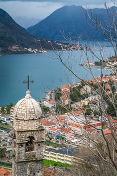 The dome and bell tower of The Chapel of Our Lady of Salvation with Kotor Bay harbour and marina below, Montenegro