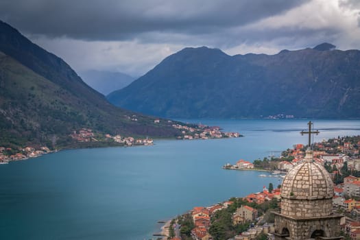 The dome and bell tower of The Chapel of Our Lady of Salvation with Kotor Bay harbour and marina below, Montenegro