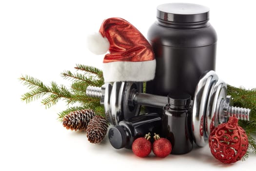 Sports nutrition (supplements), dumbbells, fir tree branches and christmas ormament on a white background. Horizontal view. New Year and Christmas. Fitness. Healthy lifestyle.