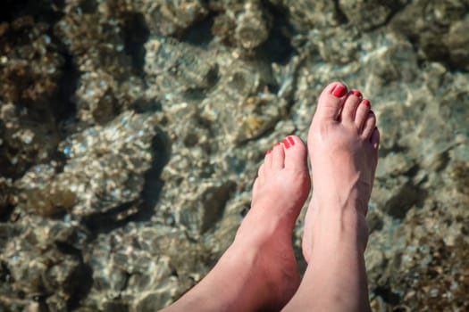 Close-up image of woman's feet over clear waters in British Virgin Islands