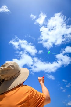A man is flying a kite on a tropical beach in the Caribbean