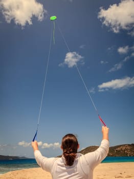 A woman is flying a kite on a tropical beach in the Caribbean