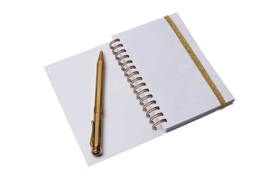 Notebook and pen. A open notebook with blank pages and an antique golden color pen isolated on a white background.