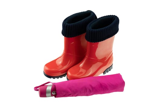 Children shoes and boots. Closeup of a pair red rubber boots and a pink umbrella isolated on a white background. Concept kids shoes fashion for rain season.