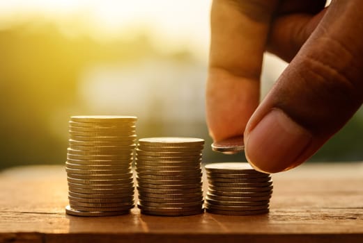 Hand with rows of coins and account for finance and banking concept, Hand with money coin stack growing business, Saving money concept