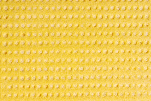 Cleaning cloth. Closeup of bright yellow viskose cleaning rag. Pattern yellow background or backdrop. Macro.