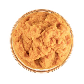 Glass bowl of pumpkin puree isolated on a white background