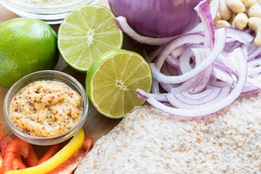 Whole wheat tortillas and fresh lime, peppers and onion for Mexican cooking.