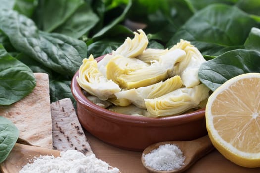 Artichoke hearts, spinach, lemon and other ingredients for vegan dip.