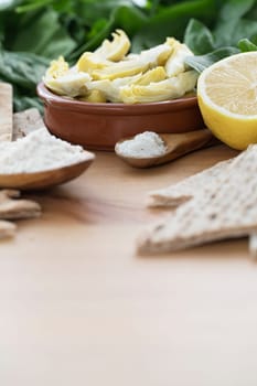 Artichoke hearts, spinach, lemon and other ingredients for vegan dip.
