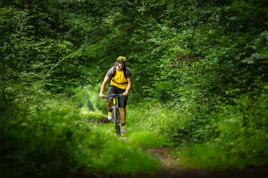 mountain biker on yellow bike in the woods
