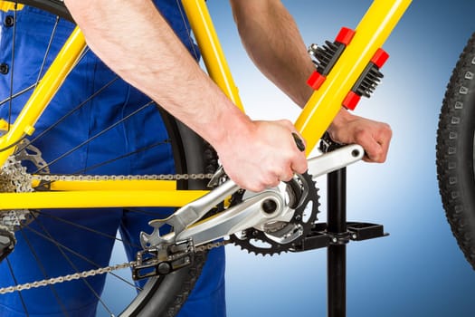 bicycle mechanic tightening pedal on mountain bike