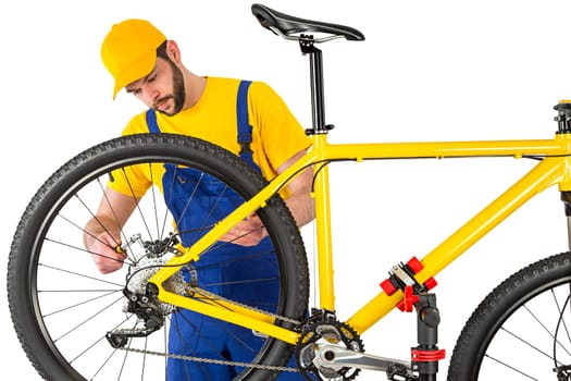 bicycle mechanic mounting brake caliper on yellow mountain bike