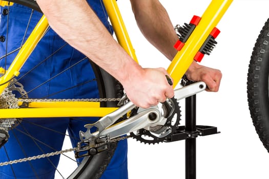 bicycle mechanic tightening pedal on mountain bike