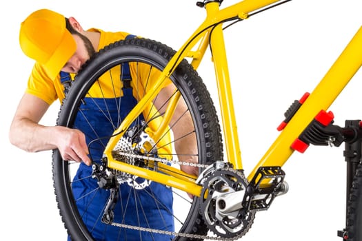 bicycle mechanic working on yellow mountain bike