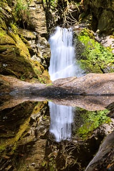 wassefall mit reflektion in einer Pfütze.