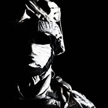 Close up portrait of modern infantry soldier, active army fighter, military mercenary in helmet, face hidden with balaclava and glasses high contrast, cropped on black background. Hybrid war concept