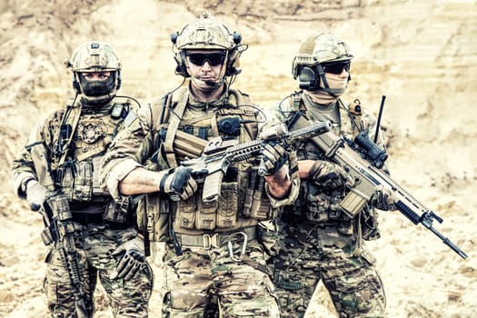 Group portrait of US army elite members, private military company servicemen, anti terrorist squad fighters standing together with guns. Brothers in arms, war conflict combatants, soldiers of fortune