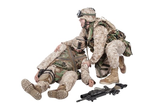 Military medic, commando shaking for shoulders, trying bring to consciousness, checking condition of unconscious, wounded soldier or comrade, isolated on white. Injured, dying infantryman rescue