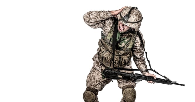Army soldier in camo uniform, armed with assault rifle and machine gun, crouching to ground, holding helmets and covers ears with hands isolated on white studio shoot Grenade or bomb explosion